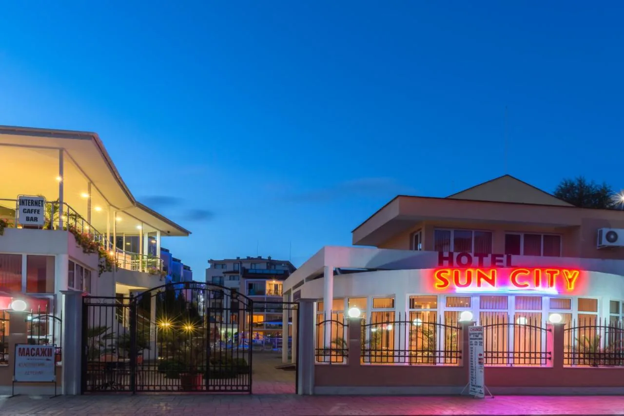 The Sun City Hotel facade at night, with the sign lit up